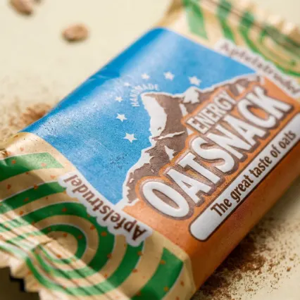 KI-Makroaufnahme eines Energy OatSnack Riegels auf Sand